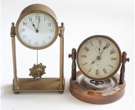 A French brass clock with suspended pendulum, with a bedside clock on wooden base. 23cm tall. (2)