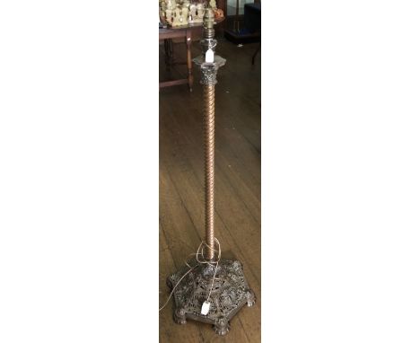 A cast and pierced iron oil lamp base with spirally turned brass column and cast and foliate pierced hexagonal base, reeded b