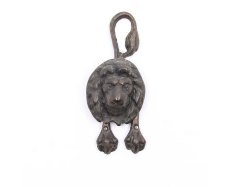 A brass lion door knocker, curved tail and three clawed front paws 15cm tall&nbsp;