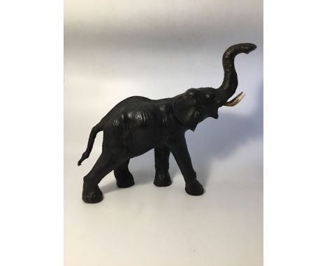 A figure of an elephant, light weight wooden carcass, covered with supple leather, cut leather ears, carved wooden tusks, gla