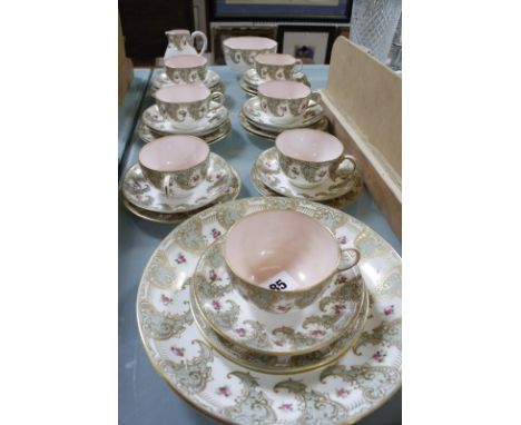 A Royal Worcester part tea service, decorated with a border of pink roses within gilt C-scroll and shaped pale-blue panels, s