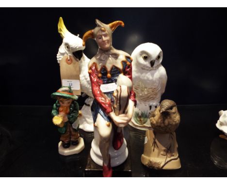 Two Crown Stafford figures of a snowy owl and a cockatoo, a Leonardo Collection figure of a jester, a Hummel style figure of 