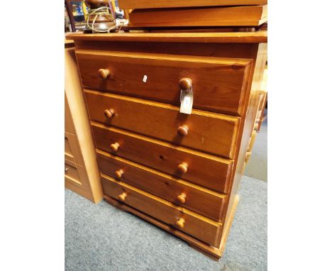 A modern pine five drawer chest having bun turned handles raised on bracket feet 
