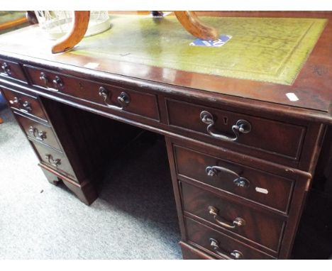 A 20thC mahogany desk the top with green leather insert over three frieze drawers over two three drawer pedestals and raised 
