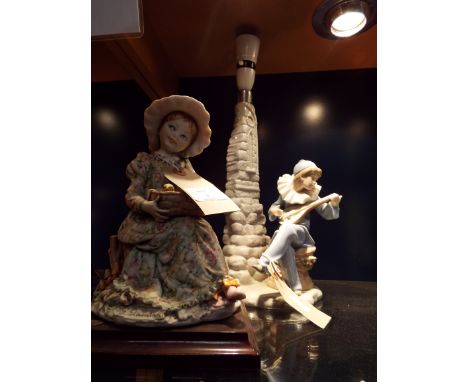 A Nao table lamp in the form of a boy playing a mandolin beside a rocky tower together with a Giuseppe Armai signed figure of