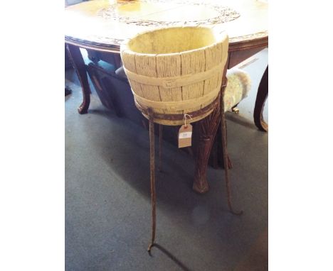 A stoneware planter in the form of a barrel raised on an iron stand