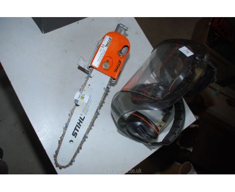 A Stihl chainsaw head for a brush cutter with ear defenders and visor.