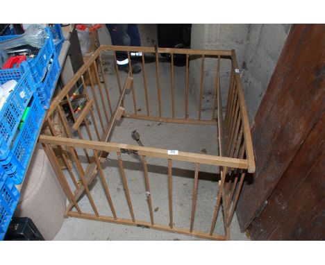 A vintage wooden fold-up play pen.
