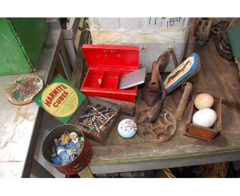 A box of two flat irons, hand drill, vintage tins and contents etc.
