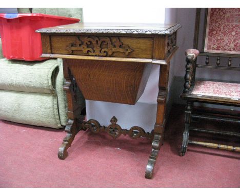 A Late XIX Century Oak Sewing Table, with carving in the Gothic manner, to moulded border and apron, bag style drop compartme