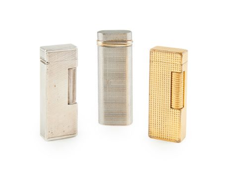 A collection of three lighters to include a Must de Cartier lighter, the textured body with gilt bands, in a Must de Cartier 