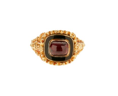 An 18ct gold Georgian memorial ring set to the centre with a cabochon red gemstone, in a black enamel border with cast detail