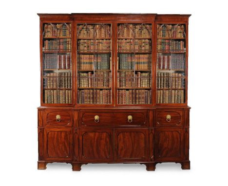 A George IV mahogany secretaire library bookcase, circa 1825, the moulded cornice above four astragal glazed doors opening to