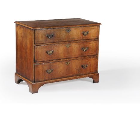 A George II walnut chest of drawers, circa 1735, the rectangular top with moulded edge, above three long graduated drawers, o