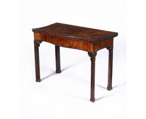 A George III mahogany serpentine concertina action folding card table, circa 1770, the hinged shaped top with foliate carved 