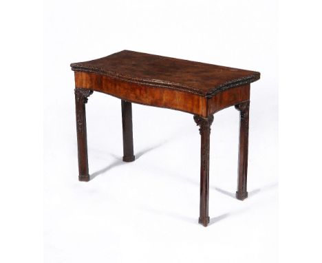 A George III mahogany serpentine concertina action folding card table, circa 1770, the hinged shaped top with foliate carved 