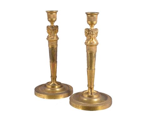 A pair of Continental, probably Russian, ormolu candlesticks in Empire style, circa 1810, the engine milled urn sconces each 