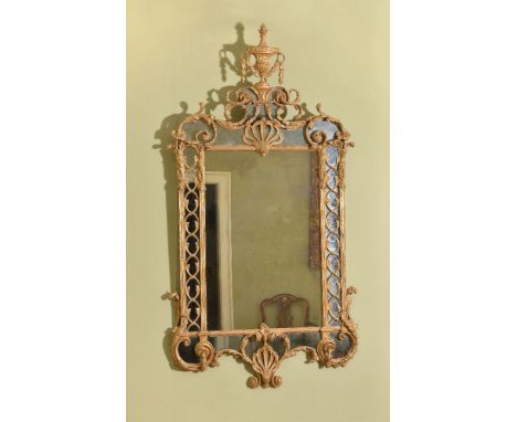 A George III carved giltwood and gesso wall mirror in the manner of Thomas Chippendale, circa 1770, the rectangular plate fla