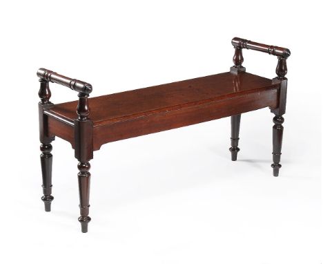 A George IV mahogany hall bench, circa 1825, the rectangular seat flanked by turned bolsters, above a plain frieze, on turned