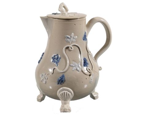 A Staffordshire salt-glazed stoneware drab bodied milk jug and cover, circa 1730, applied in relief with pipe-clay tendrils a
