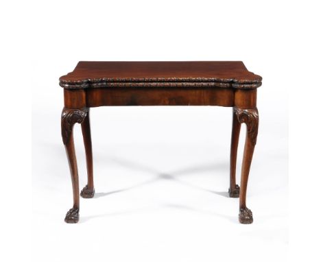 A George II mahogany concertina action card table, circa 1750, the hinged and shaped top with floral moulded edge, opening to