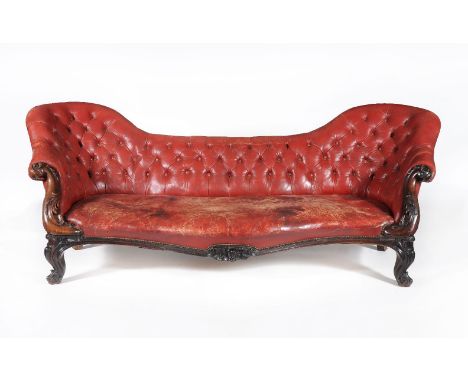 A Victorian rosewood and buttoned leather upholstered sofa, circa 1860, the yoke shaped back above the serpentine fronted sea