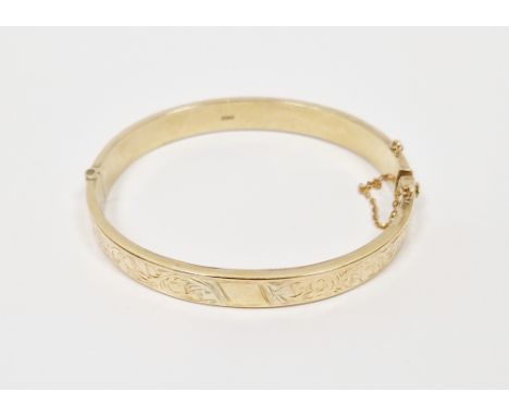 9ct gold flattened bangle with engraved decoration, 10.3g   Condition Report Some surface wear and scratches throughout. Some