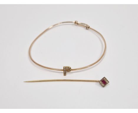 Yellow-metal ruby and diamond stick pin, the square head set with a central mixed cut ruby flanked either side by three diamo