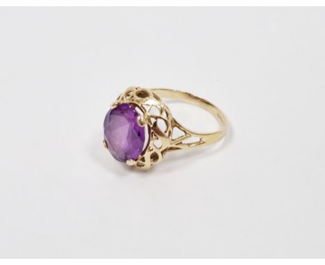14K gold and purple stone ring, the oval stone in scroll bordered mount (size P)&nbsp;