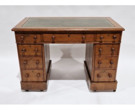 Mid Victorian oak twin-pedestal desk, the green leather inset top with thumbnail moulded edge, over an arrangement of nine dr