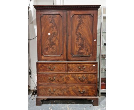 George III mahogany linen press, the cornice with dentil moulding over two panel doors opening to two linen slides, over two 