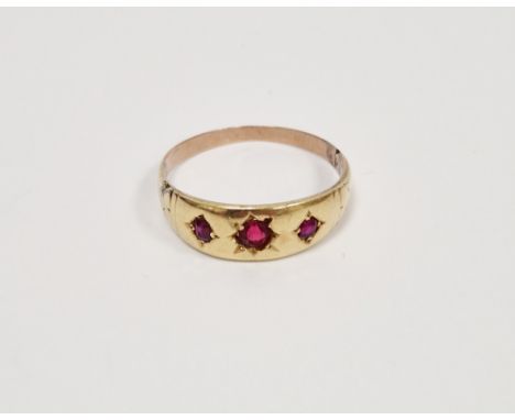 Late 19th / early 20th century yellow-metal ring set with a row of three round mixed cut rubies in star-cut settings, ring si