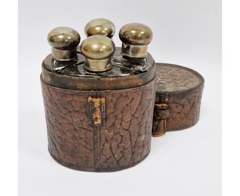 Early 20th century four-bottle cologne or spirit flask set, each with silver plated screw-on caps and glass stoppers, contain