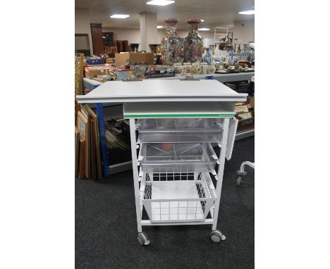 A metal medical trolley with two plastic trays and adjustable shelf and wire mesh basket