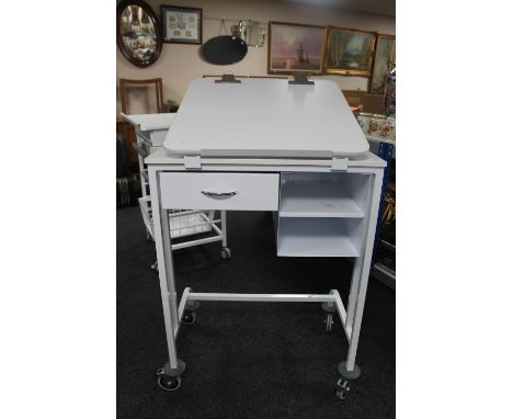 A metal medical trolley fitted with drawers with adjustable shelf