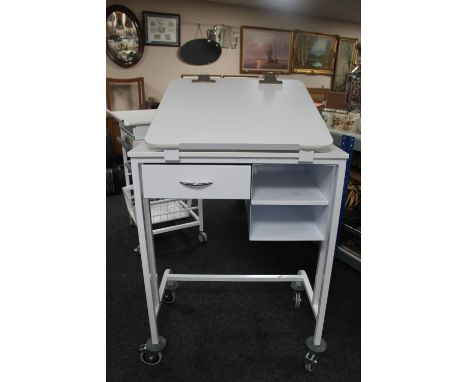 A metal medical trolley fitted with drawers with adjustable shelf