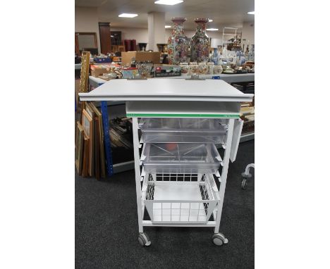 A metal medical trolley with two plastic trays and adjustable shelf and wire mesh basket