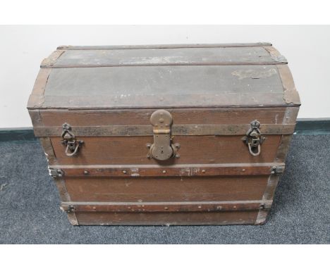 An antique wooden bound domed shipping trunk 