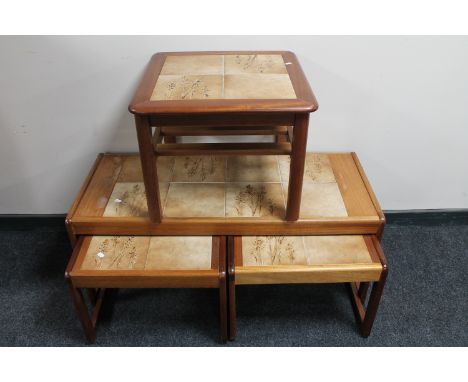 A nest of three teak tiled tables together with a tiled lamp table 