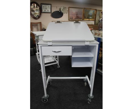 A metal medical trolley fitted with drawers with adjustable shelf