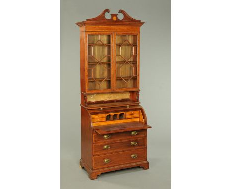 An Edwardian inlaid mahogany cylinder bureau, with swans neck pediment above a pair of glazed doors with wooden astragals enc