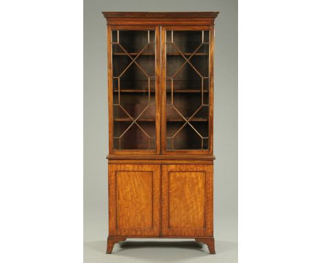 An Edwardian mahogany bookcase, with moulded Greek key cornice above a pair of glazed doors with wooden astragals enclosing s