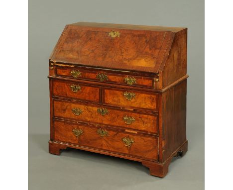 An 18th century walnut bureau, crossbanded, with fitted interior with well and with one long, two short and two long drawers 