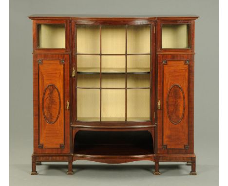 An Edwardian mahogany display case, with bowed front and fitted with a series of glazed and panelled doors, with open centre 