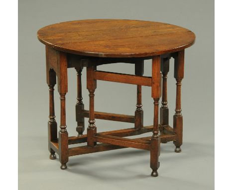 A small 18th century oak gate leg table, oval, raised on turned legs with stretchers.  Width 80.5 cm, length open 85 cm.     