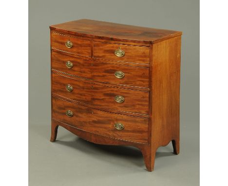 A George III mahogany bowfronted chest of drawers, with two short and three long graduated drawers with brass drop handles wi