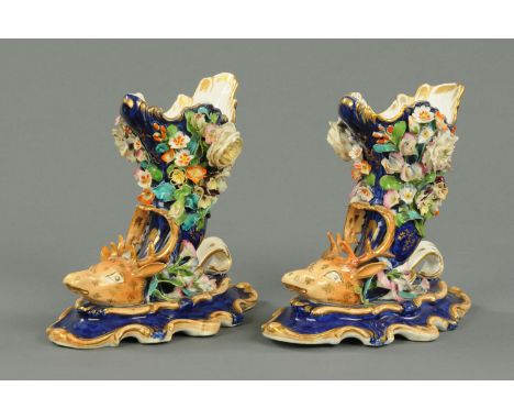 A pair of 19th century floral encrusted cornucopia with stag head terminals, decorated in a variety of bright enamel colours.