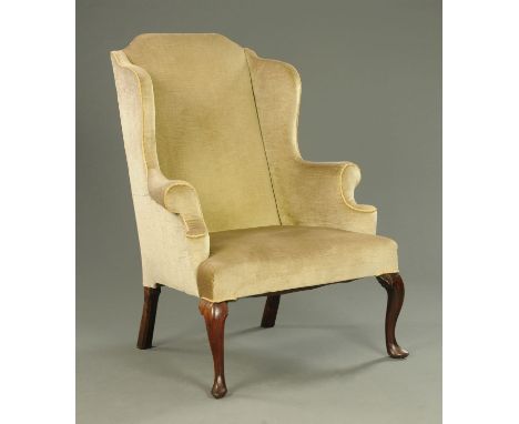 An early 18th century wing easy chair, raised on front cabriole legs and rear chamfered angled legs.  Width across arms 53 cm