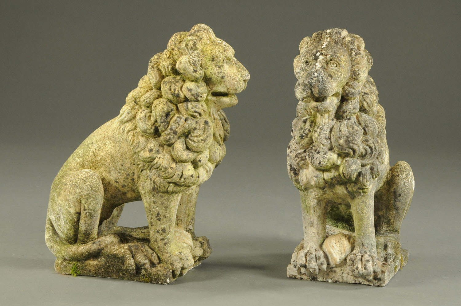 A pair of simulated sandstone garden lion ornaments. Height 59 cm (see