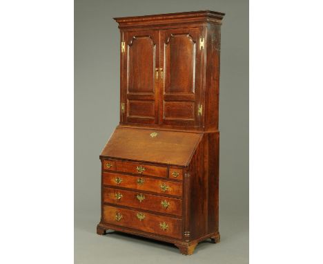 An 18th century oak bureau bookcase, with moulded cornice above a pair of panelled doors opening to shelves, the base with sl